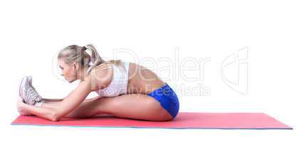 Attractive sporty girl doing exercises on mat