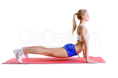 Flexible blonde practices aerobics on mat