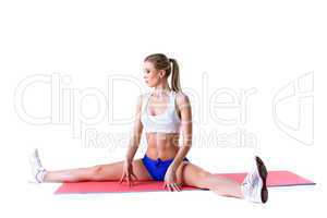 Athletic woman practices aerobics on mat
