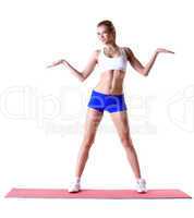 Cheerful slim woman posing on mat in studio