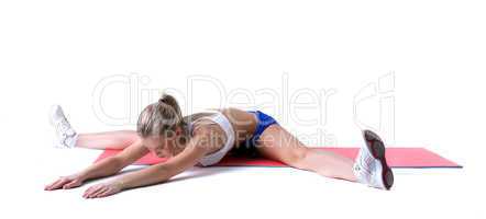 Athletic girl doing stretching exercises on mat