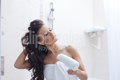 Curly brunette posing with hairdryer