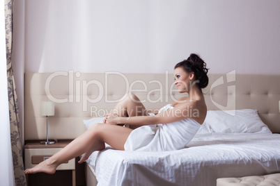 Smiling young girl sitting on bed