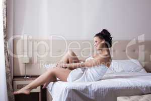 Smiling young girl sitting on bed