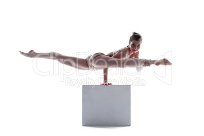 Attractive gymnast doing exercises on cube