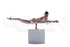 Attractive gymnast doing exercises on cube