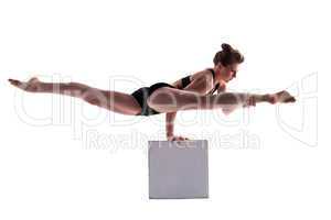 Young pretty brunette doing exercises on cube