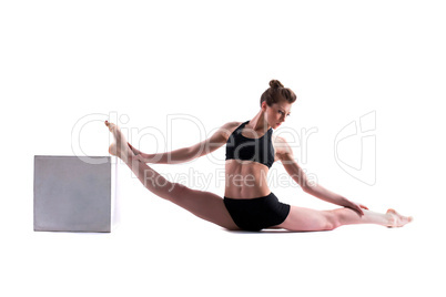 Attractive gymnast posing with cube in studio