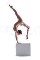 Young flexible woman posing on cube