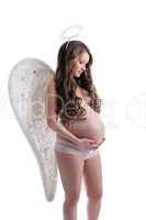Beautiful pregnant woman posing in angel costume