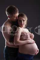 Lovely pregnant woman and man in studio