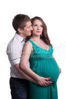 Beautiful pregnant woman with man posing in studio