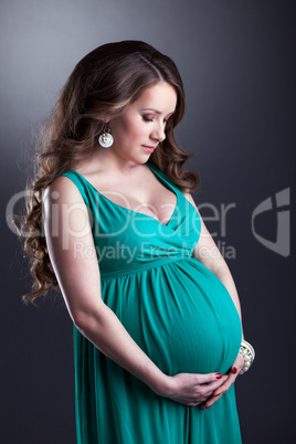 Pretty pregnant woman caressing her belly