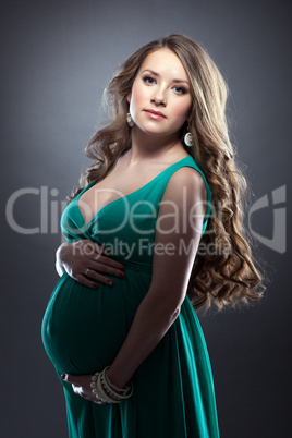 Young expectant woman posing in green dress