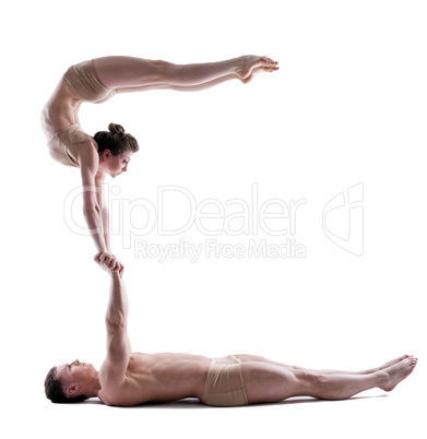 Image of two young acrobats balancing in studio