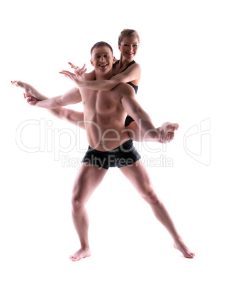 Two young smiling acrobats posing in studio