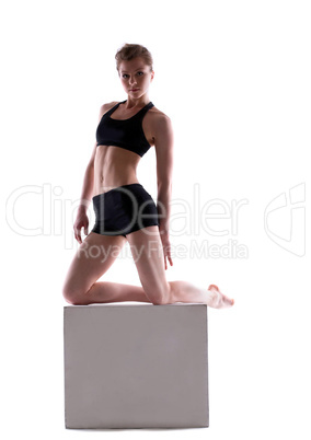 Sporty woman posing with cube looking at camera