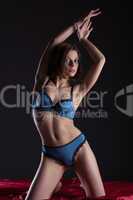 Young slender woman posing in blue lingerie