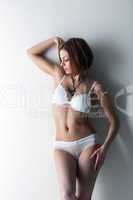 Attractive slim girl posing in white lingerie