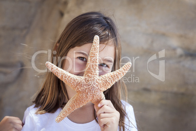 Young Girl Playing with Starfish