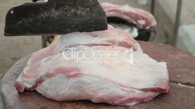Butcher cutting fresh pork meat
