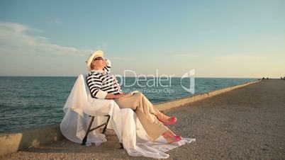 Senior woman looking to sea at sunset