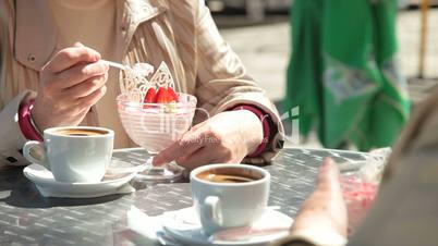 Senior Female Friends Eating Dessert At Outdoor Cafe