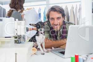 Smiling fashion designer with his chihuahua