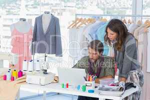 Two fashion designers working on laptop