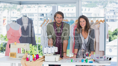 Fashion designers leaning on desk