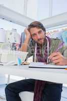 Attractive fashion designer working at his desk