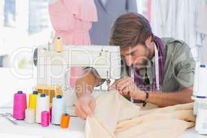 Handsome fashion designer sewing