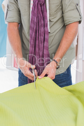 Fashion designer cutting green textile