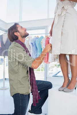 Fashion designer looking at model