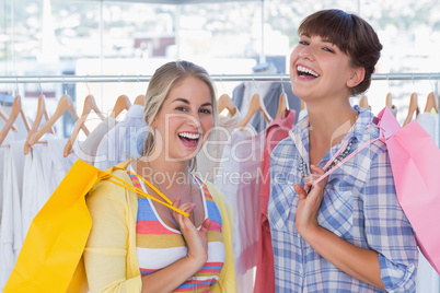 Two cheerful friends holding shopping bags