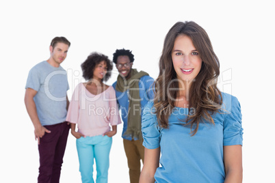 Stylish woman smiling with people gesturing behind her