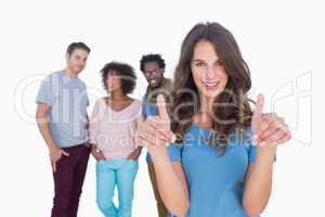 Woman with thumbs standing in front of stylish people