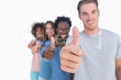 Young people in row with thumbs up