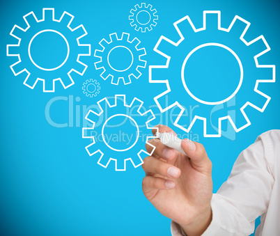 Businessman drawing wheels and cogs