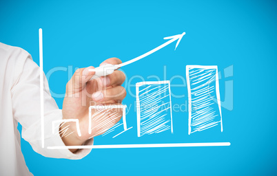 Businessman drawing white arrow above graph