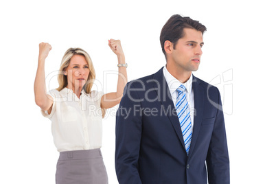 Businessman and a serious businesswoman with raised arms