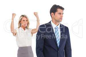 Businessman and a serious businesswoman with raised arms