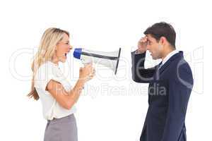 Businesswoman shouting at a businessman with megaphone