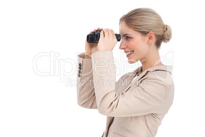 Smiling businesswoman looking away with binoculars