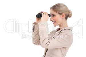 Smiling businesswoman looking away with binoculars