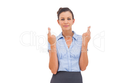 Smiling businesswoman with fingers crossed