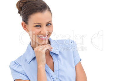 Cheerful businesswoman with hand on chin