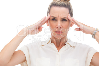 Wincing businesswoman with hand on head