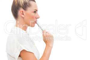 Businesswoman with pen on mouth