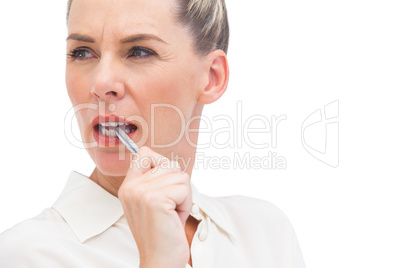 Businesswoman thinking with pen on mouth